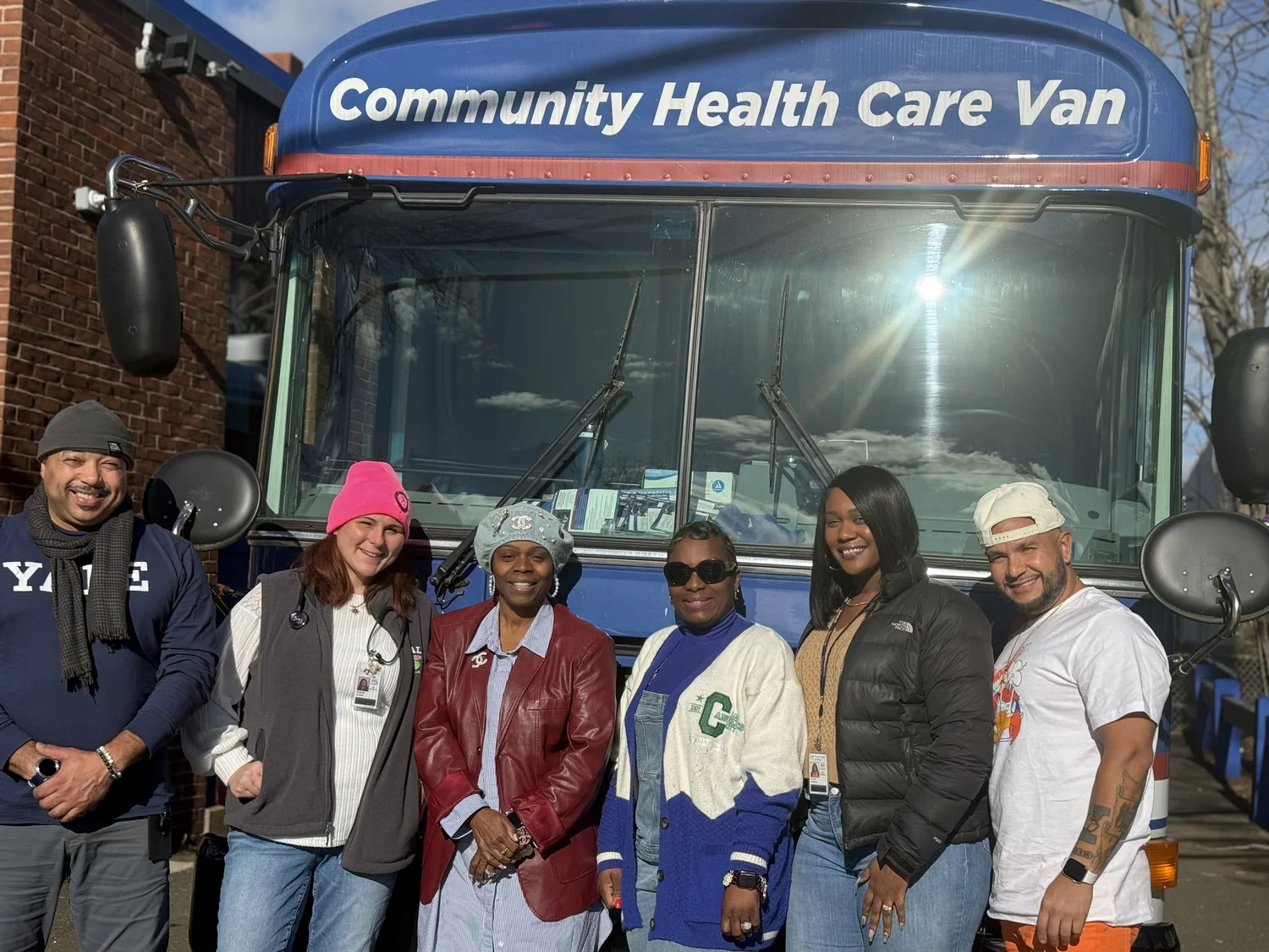 Shelter guests and staff gathered in front of the Community Health Care Van