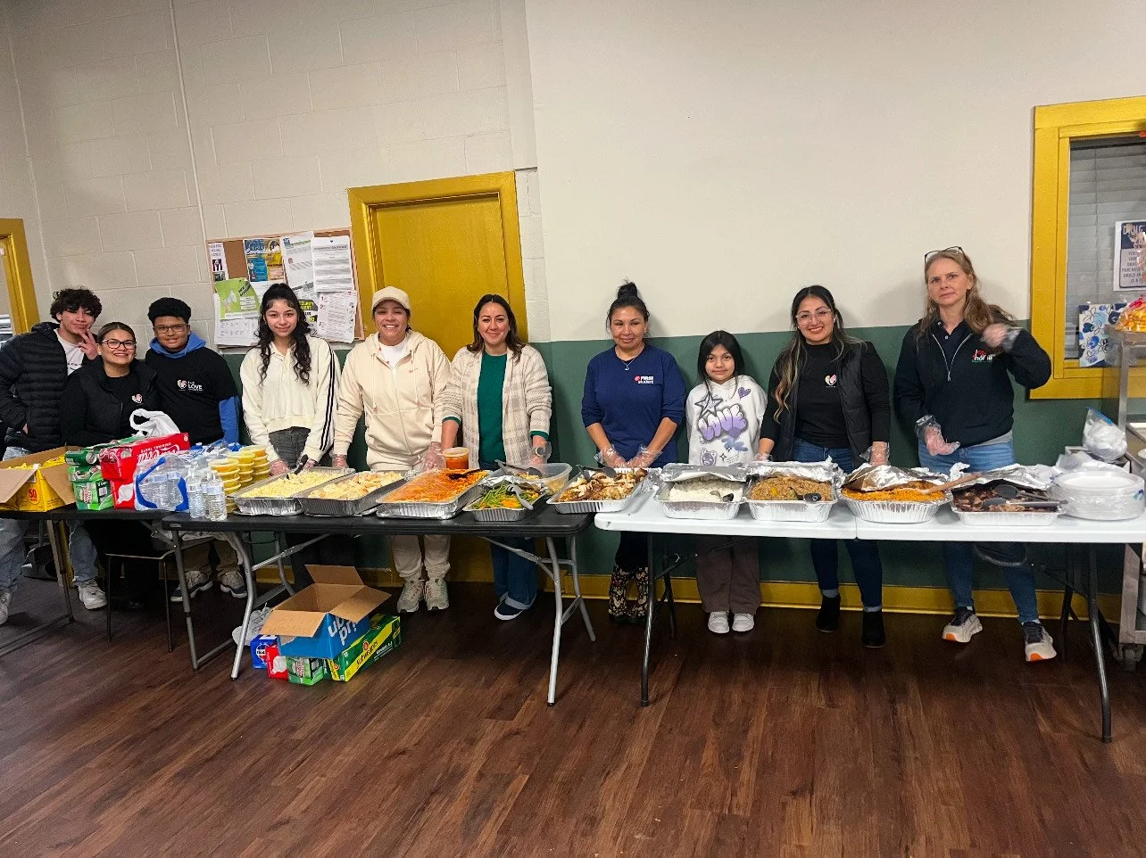 Volunteer group standing behind a table of donated goods