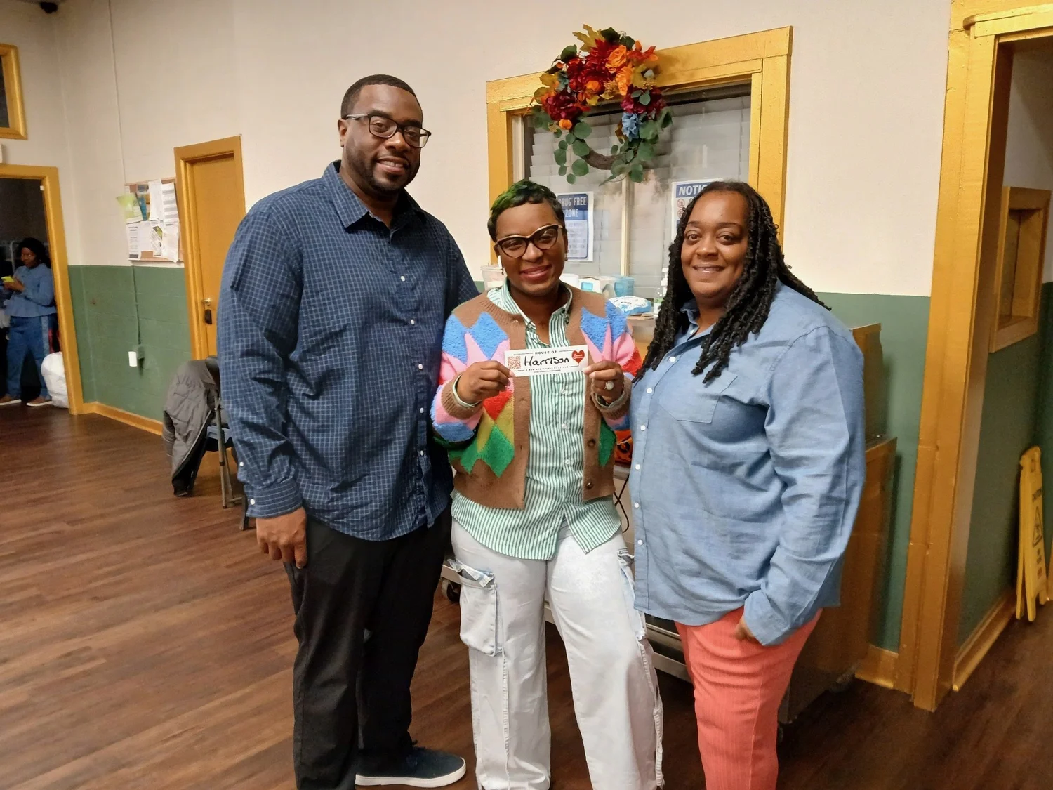 Three shelter staff members smiling together in the hallway
